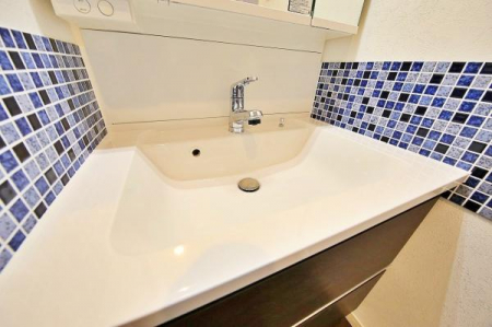 洗面台・洗面所　いつでもきれいに保ちたい空間のひとつ。鏡の裏や下の引き出しにしっかり収納できる三面鏡タイプの洗面化粧台をチョイス。