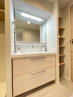 洗面台・洗面所　収納力豊富な三面鏡の洗面台。右側にはリネン棚もあり、小物が増える水回りをすっきりさせます。
